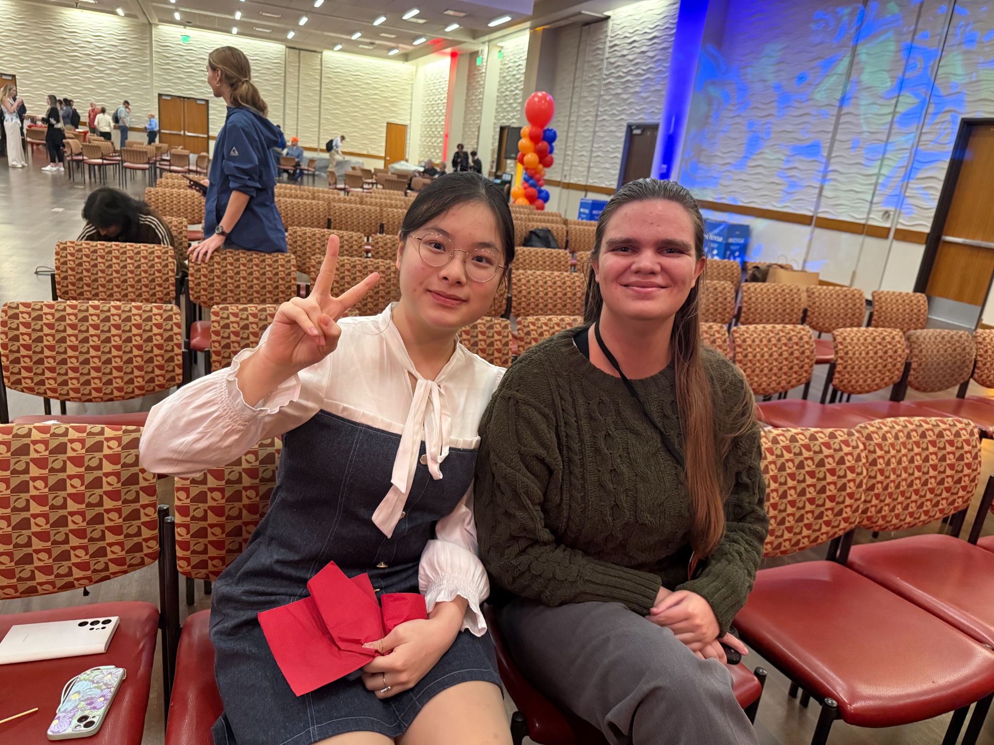 Irene 与 Phoebe 在会场座位间合影